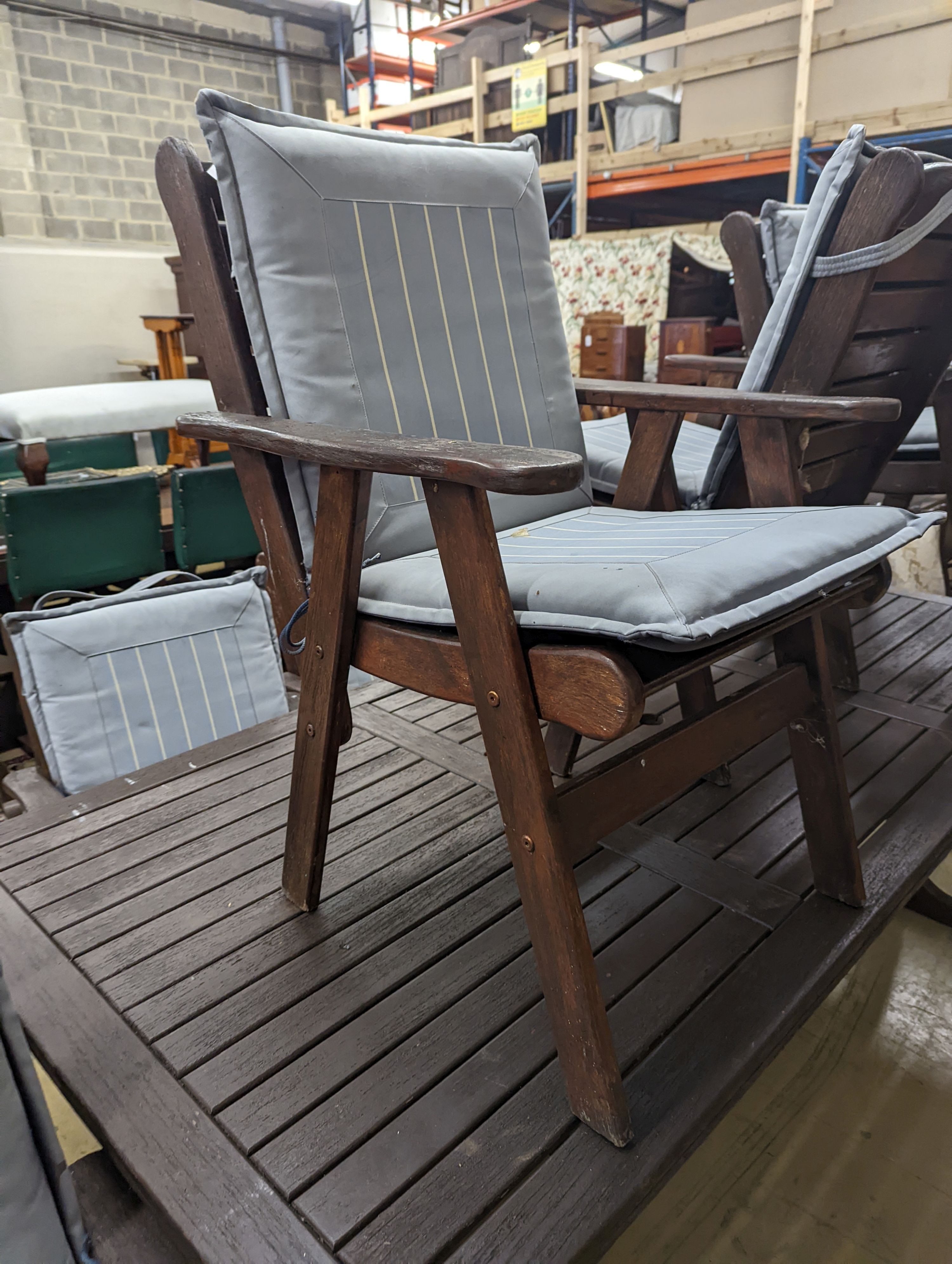 A Fechters stained teak rectangular garden table, length 220cm, depth 107cm, height 72cm and eight elbow chairs and seat pads